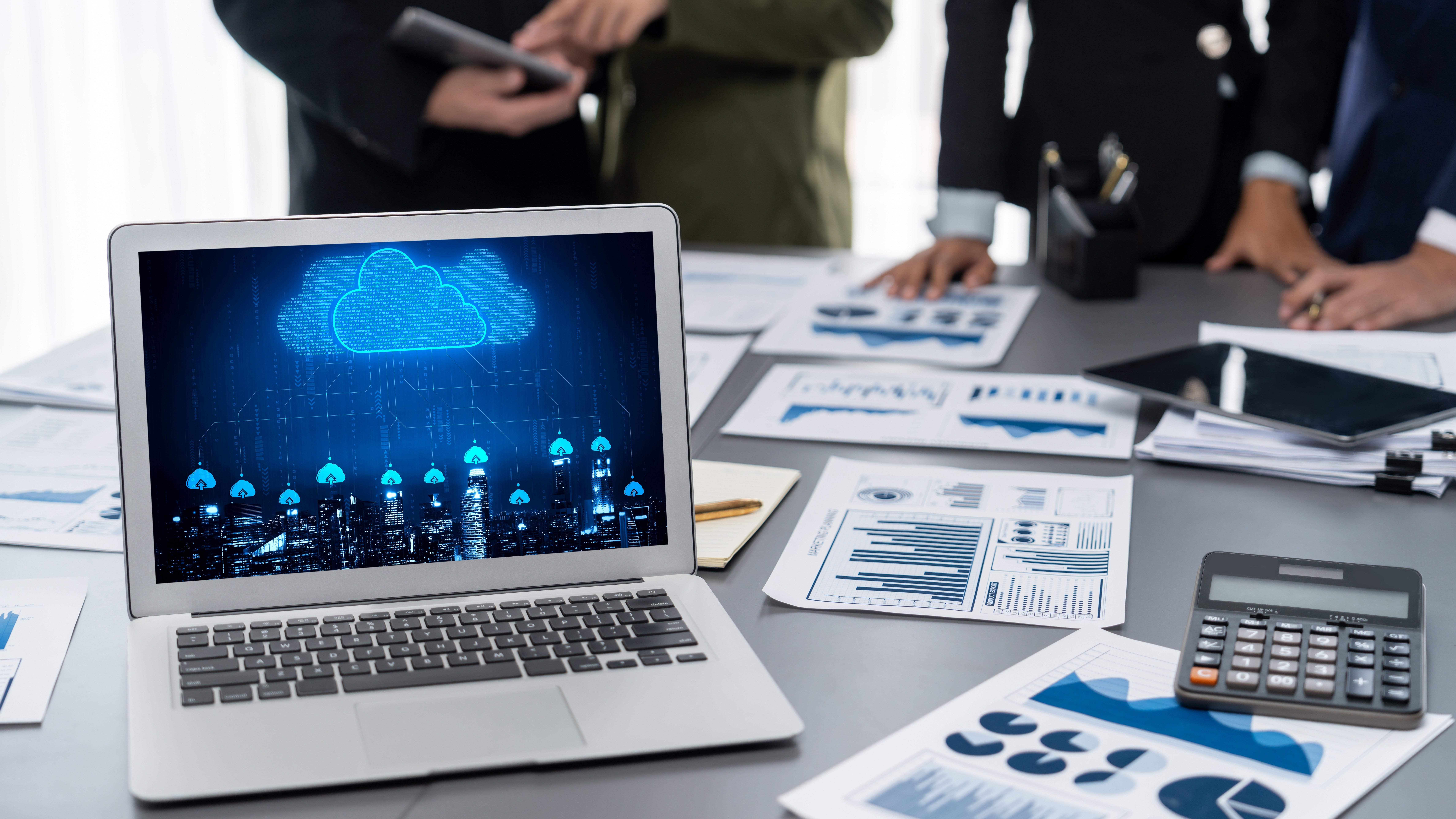 Laptop with papers around it 